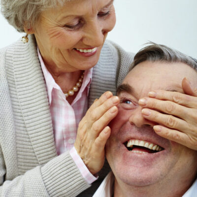 Elderly couple smiling and being playful