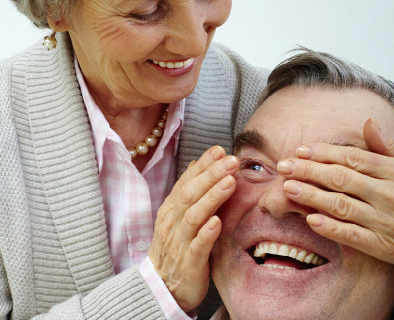 Elderly couple smiling and being playful