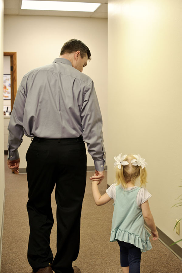 Little girl holding hands with man while walking away