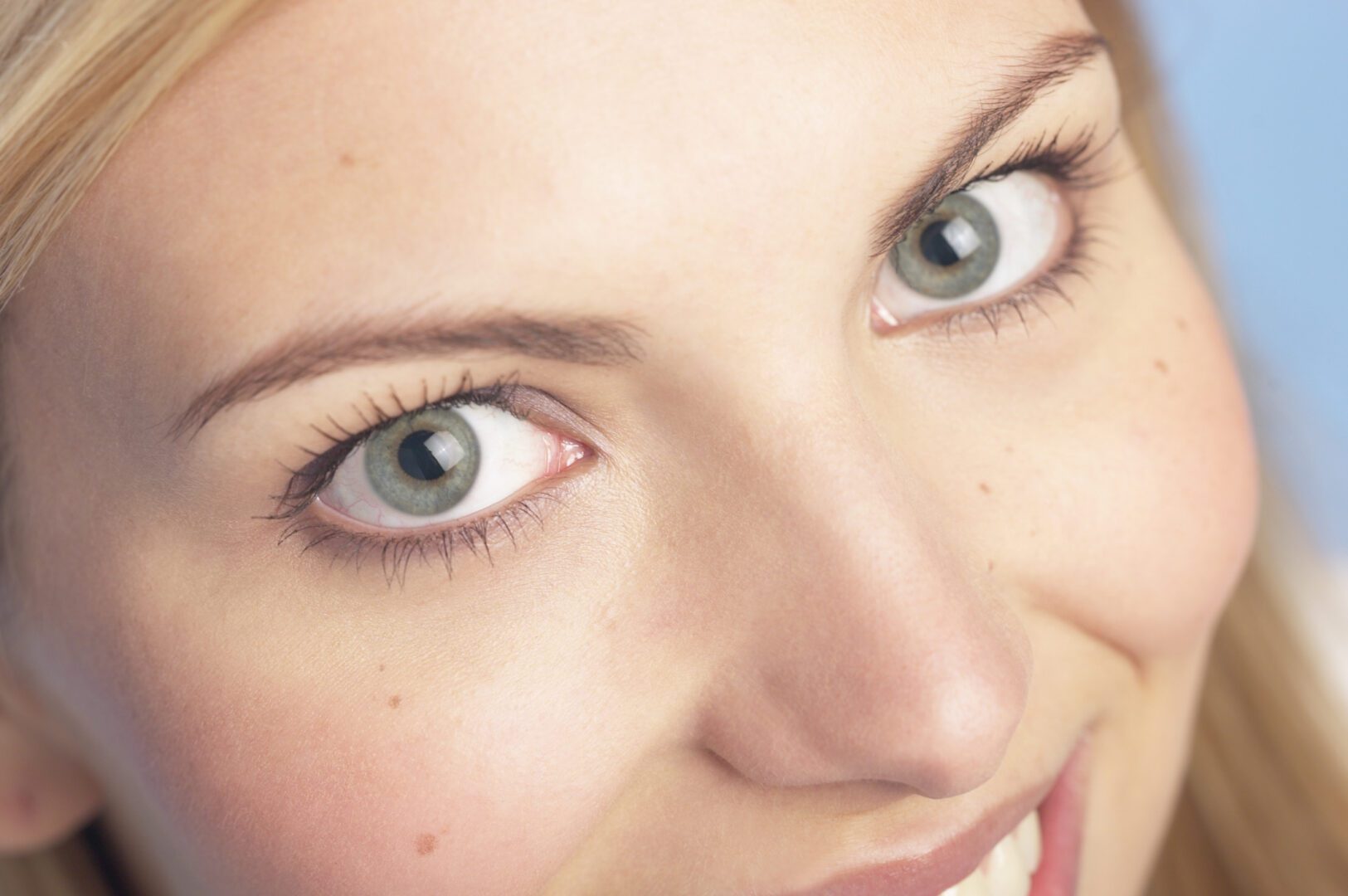 Smiling woman's green eyes and freckled cheek