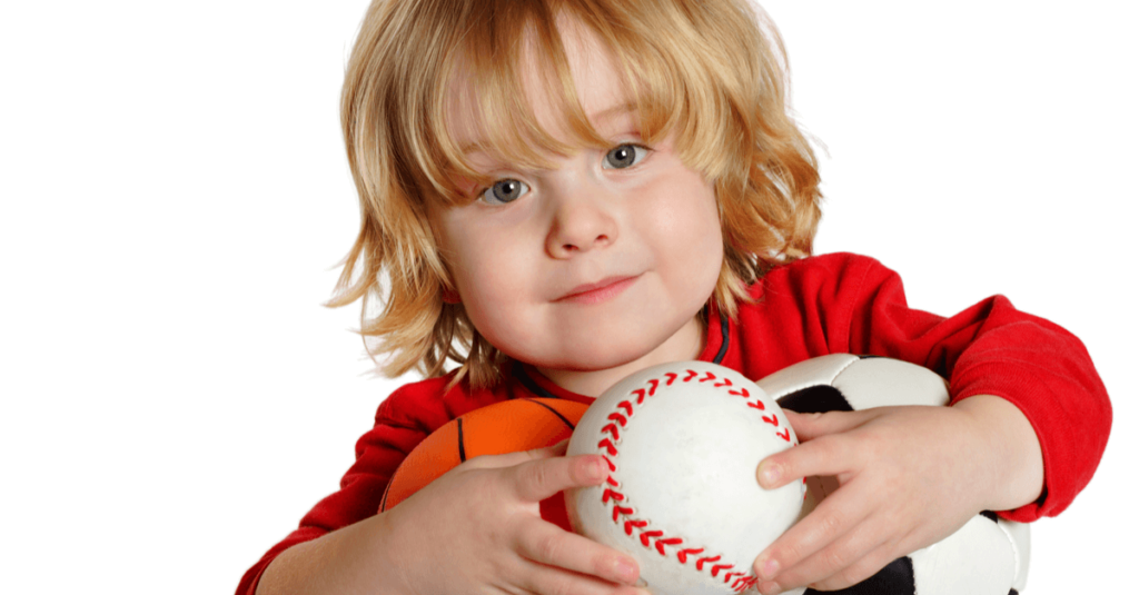 Blonde, shaggy-haired child with healthy green eyes holding sports balls